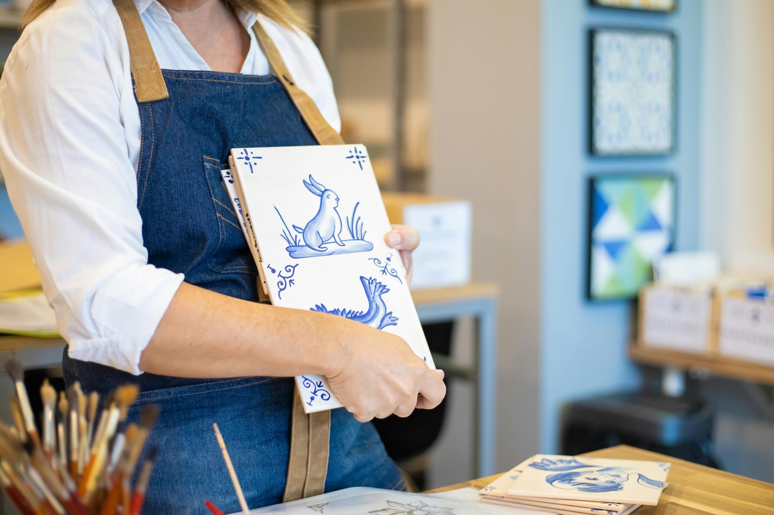 Artisan tenant des azulejos bleu et blanc dans un atelier traditionnel